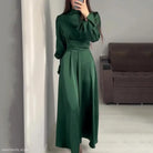 Elegant emerald green puff sleeve dress with a belted mock neck and cinched waist