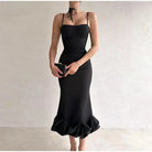 Elegant black mermaid-style dress with spaghetti straps and a ruffled hem.