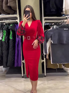 Red midi dress with a v-neck, puff sleeves, and a rhinestone-studded belt.