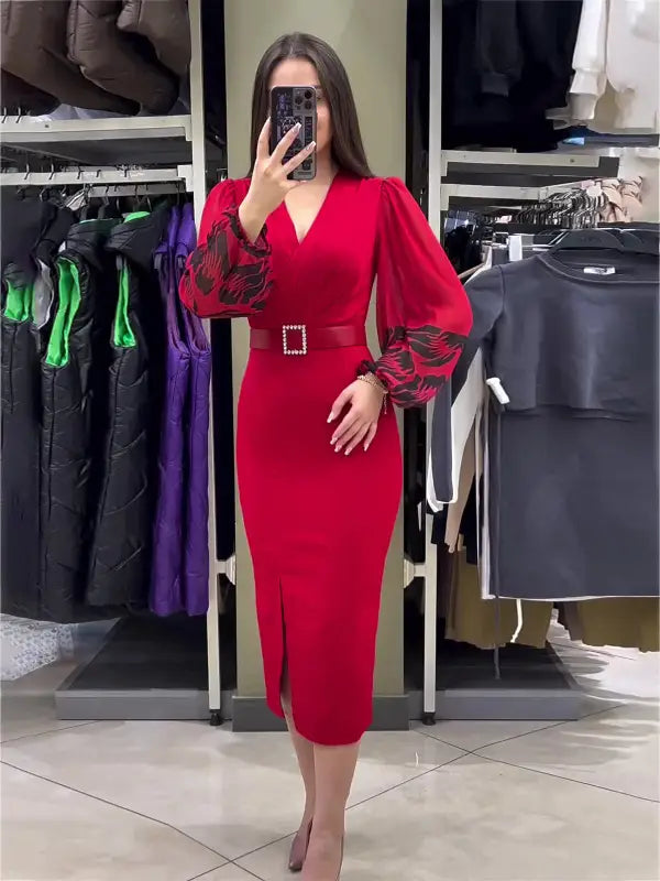 Vibrant red dress with puffed sleeves, a belted waist, and a side slit.