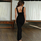 Long black form-fitting dress with wide shoulder straps.