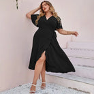 Black wrap dress with short sleeves and a side slit.