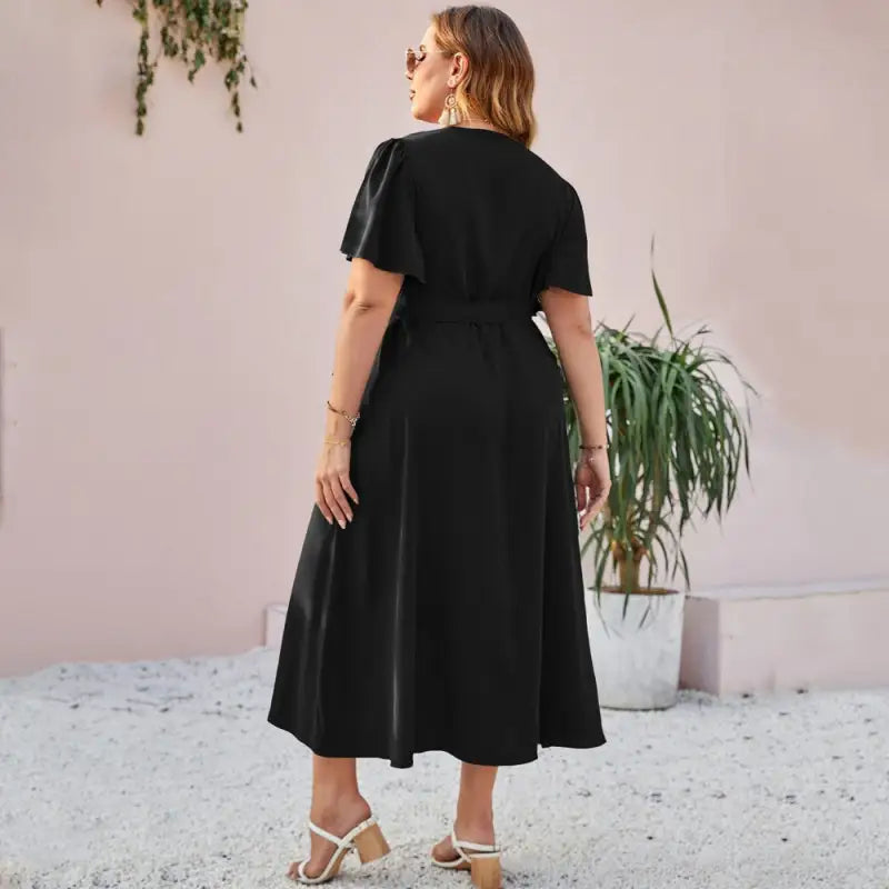 Black midi dress with short sleeves and a flared skirt worn by a woman.