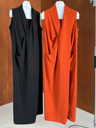 Two sleeveless, floor-length dresses with draped fronts in black and bright orange.