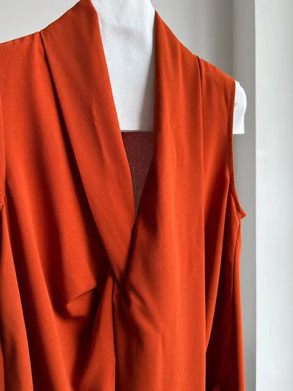 Bright orange draped garment with flowing folds and an open front.