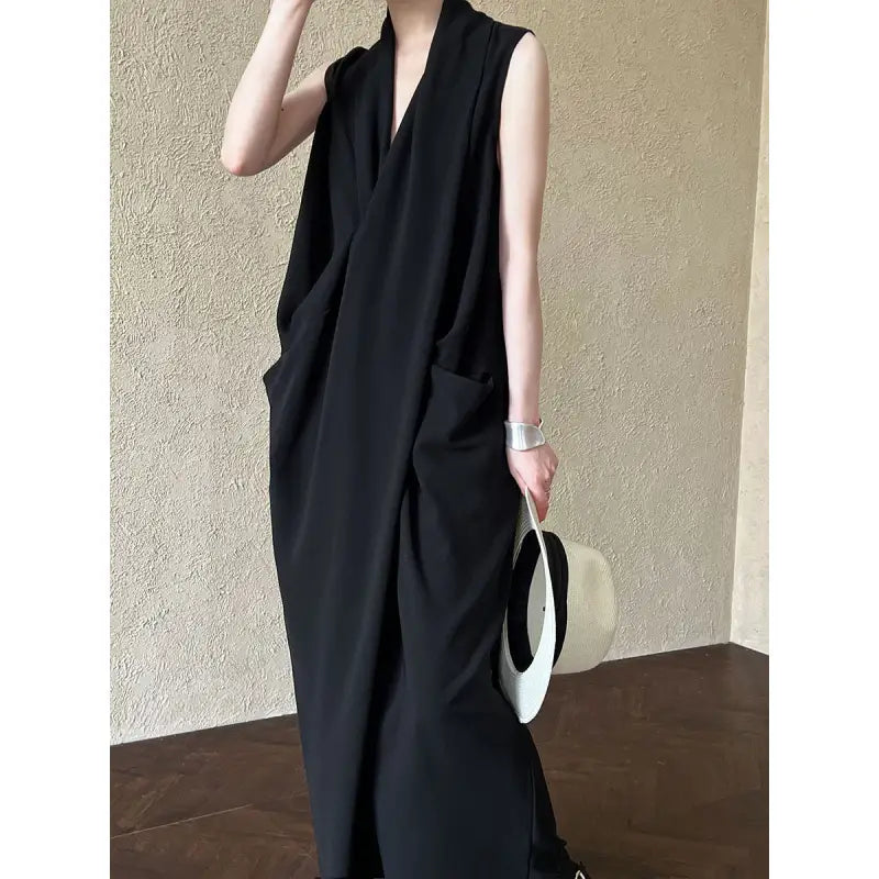 Sleeveless black maxi dress with a deep V-neck and side pockets.