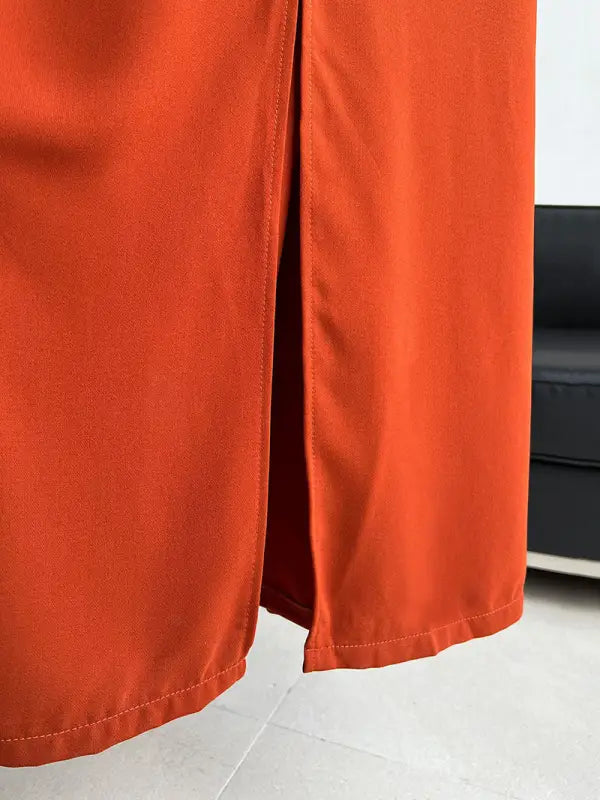 Bright orange pants or trousers with a side slit detail.