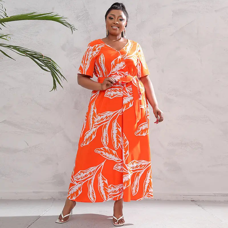 Vibrant orange maxi dress with white leaf print and short sleeves.