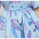 Light blue dress with a feather print pattern and a tied waist belt.