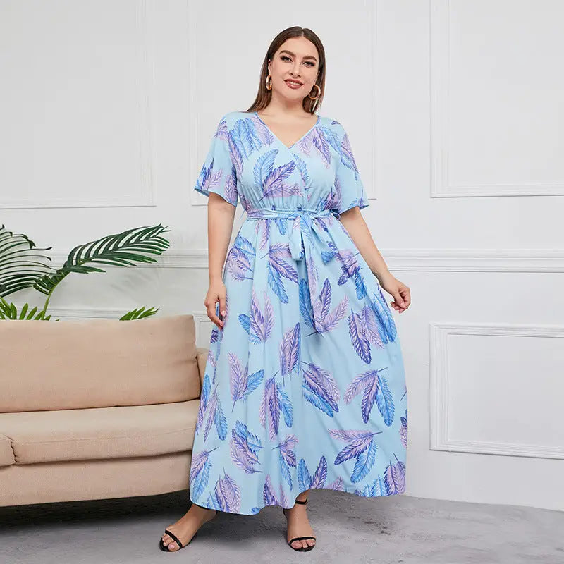 Light blue maxi dress with purple and blue feather print, featuring short sleeves and a belted waist.