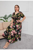 Floral maxi dress with a black background and vibrant pink and green floral print.