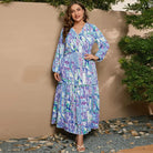 Floral print maxi dress with long sleeves and a tiered skirt in shades of blue and purple.