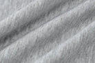 Textured gray fabric with diagonal folds or creases.