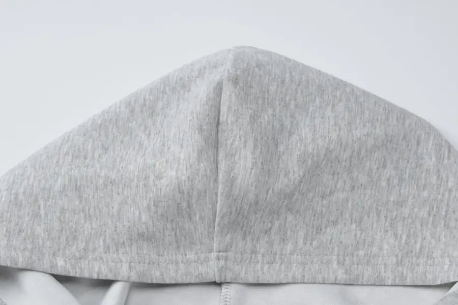 Gray fabric hood or cap with a seam down the center.