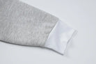 Sleeve of a gray and white two-toned garment.