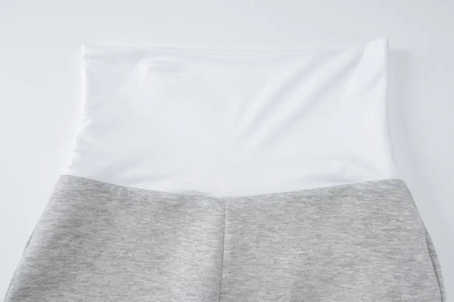 White pillow resting on gray fabric or bedding.