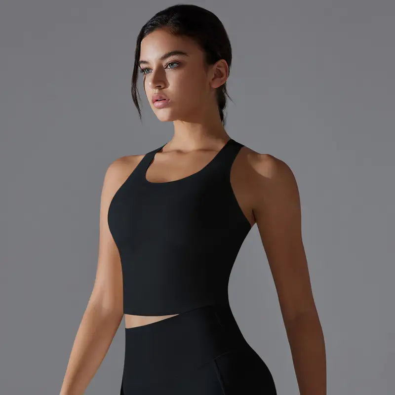 Young woman wearing a sleek black athletic top with a cutout detail.