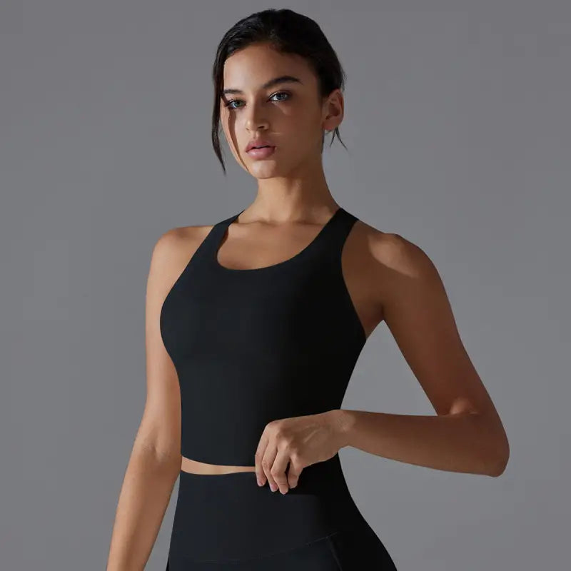 Woman wearing a black athletic crop top and matching bottoms.