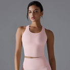 Woman wearing a light pink sleeveless athletic top.