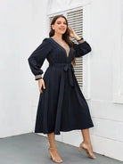 Navy blue wrap dress with long sleeves and a belted waist.