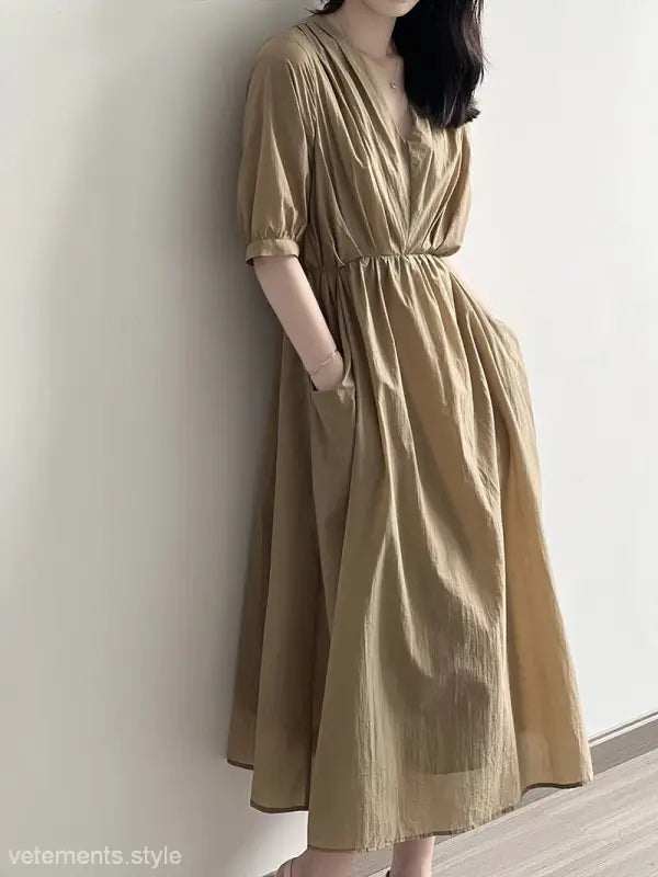 Flowy beige retro v neck pleated dress with elbow-length sleeves and cinched waist