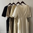 Four neutral-colored Retro V Neck Pleated Midi Dresses on hangers for stylish display