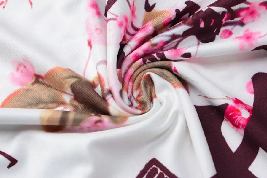 Swirled fabric with a floral pattern in pink, burgundy, and white tones.