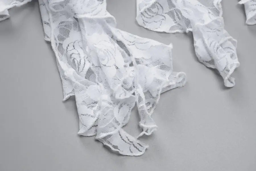 Torn or shredded pieces of white lace fabric.