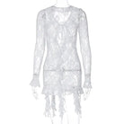 White lace dress with long sleeves and an asymmetrical hem.