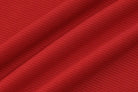 Red textured fabric with diagonal folds or pleats.