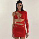 Red asymmetrical cutout dress with one long sleeve and strategic openings revealing skin.