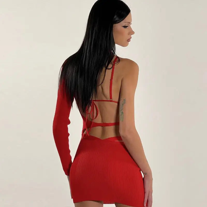 Red backless dress with one long sleeve and a short skirt.