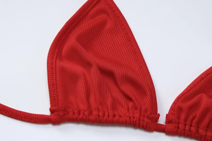 Red triangular fabric piece with elastic gathering, likely part of a bikini top or bra.