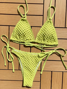 Lime green crocheted bikini with a textured pattern.