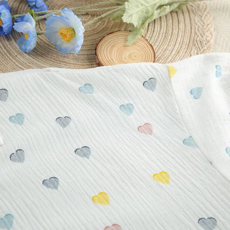 Fabric with a pattern of small colorful heart shapes.