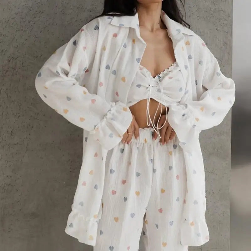 White button-up shirt with colorful heart patterns worn over a cropped top and matching shorts.