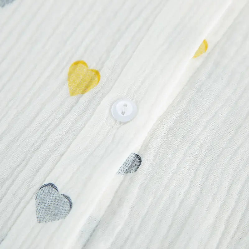 White button-up shirt with yellow and gray heart-shaped decorations.