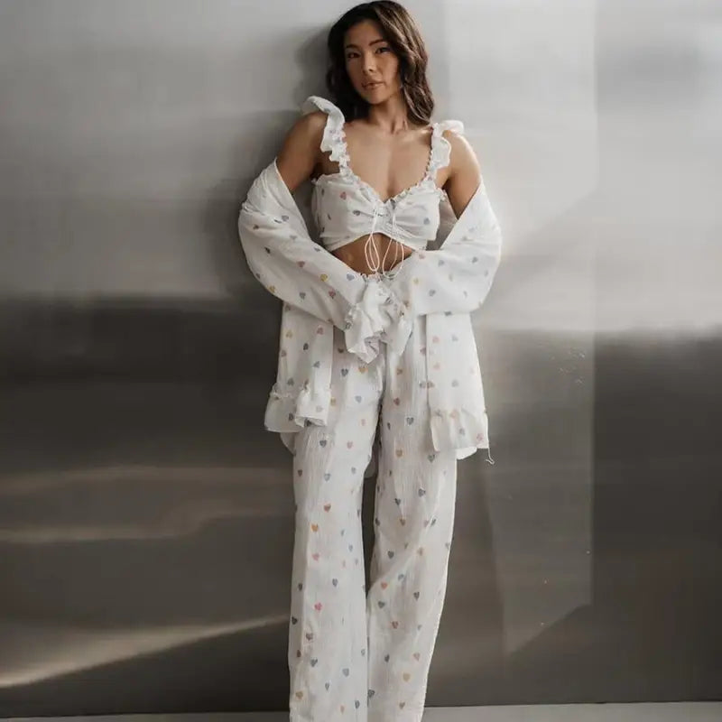 Woman wearing a white patterned pajama set with a cropped top and wide-leg pants.