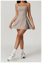 Beige spaghetti-strap mini dress with a flared skirt.