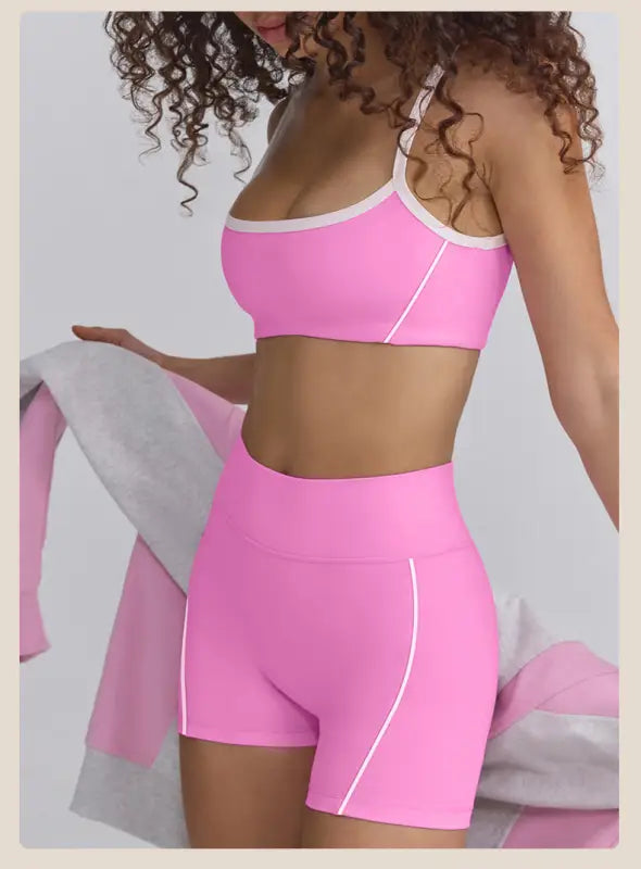 Bright pink workout set consisting of a sports bra and high-waisted shorts.