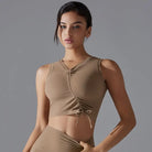 Young woman wearing a beige crop top with lace-up detailing.