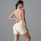 Cream-colored bodysuit with crisscross straps on the back.