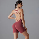 Burgundy-colored workout bodysuit with crisscross back straps and short legs.