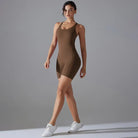 Brown form-fitting bodysuit worn by a woman with white sneakers.