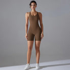 Brown sleeveless bodysuit worn by a woman with white sneakers.