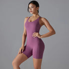 Purple form-fitting athletic bodysuit or unitard worn by a woman.