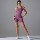 Purple sleeveless athletic bodysuit worn by a woman with white sneakers.