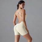 Cream-colored bodysuit with criss-cross back straps and short legs.